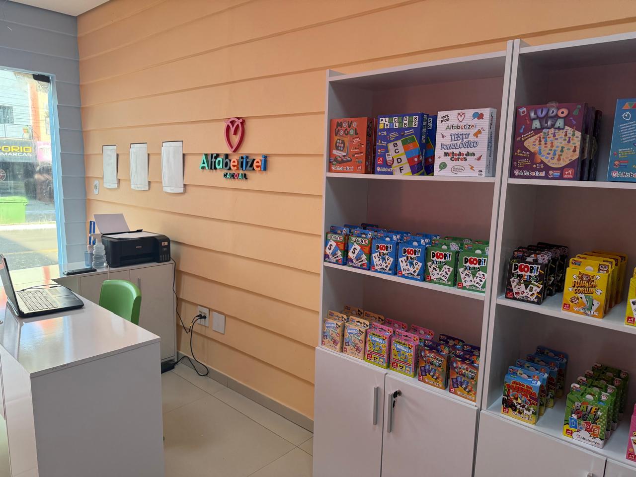 Prateleiras com jogos e materiais autorais Alfabetizei